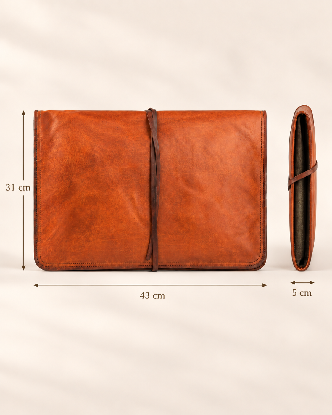 A brown leather laptop sleeve cover shown from the front and side, with dimension labels indicating 31 cm height, 43 cm width, and 5 cm thickness on a light neutral background.