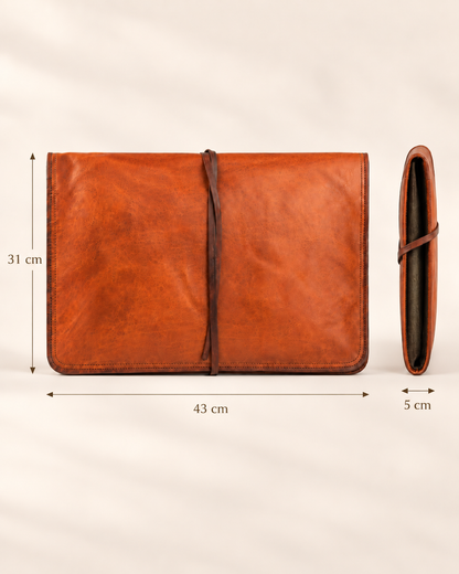 A brown leather laptop sleeve cover shown from the front and side, with dimension labels indicating 31 cm height, 43 cm width, and 5 cm thickness on a light neutral background.