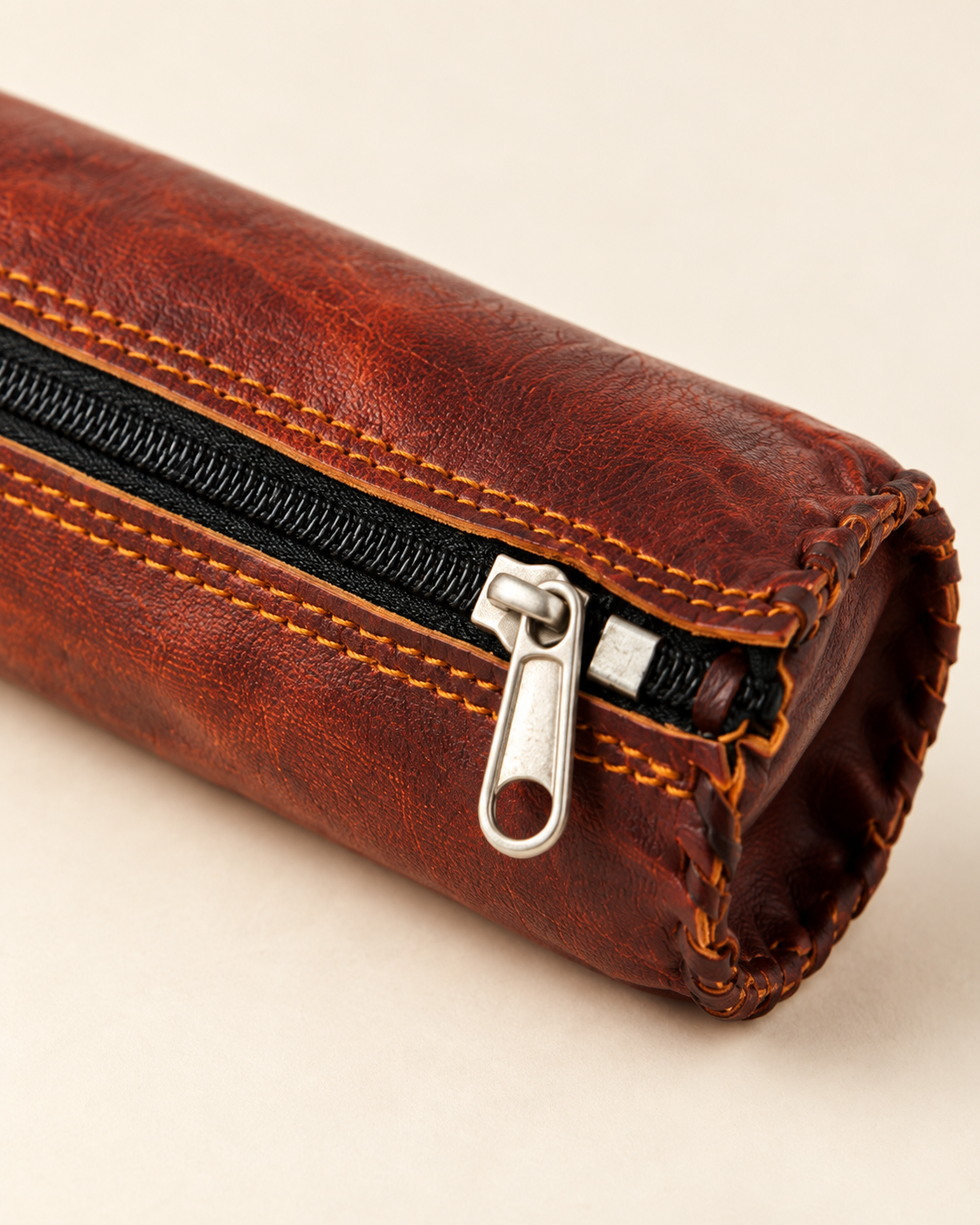 Close-up of full-grain leather, contrast stitching and metal zipper