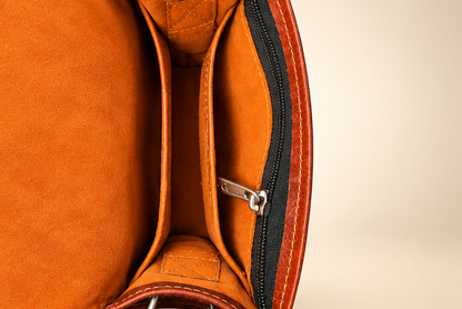 A four-panel product collage showing a brown leather shoulder bag from multiple angles: front view, side profile, open interior, and front flap detail with floral tooling. The bag has a warm medium-brown color, black zipper trim, silver hardware, and a tan interior lining.